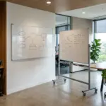 Fixed wall-mounted whiteboard beside a mobile whiteboard