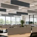 Modern open-plan office with suspended acoustic ceiling panels above workstations