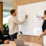 Team comparing magnetic and non-magnetic whiteboard uses in a modern office