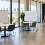 Three mobile whiteboards positioned at separate workshop tables.